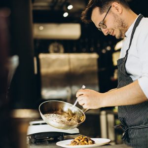 Man chef cooking asian chicken at a cafe kitchen